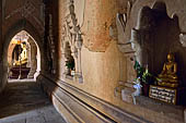 Bagan Myanmar. Htilominlo temple. Niches of the vaulted corridor of the ground floor with stone Buddha images. 